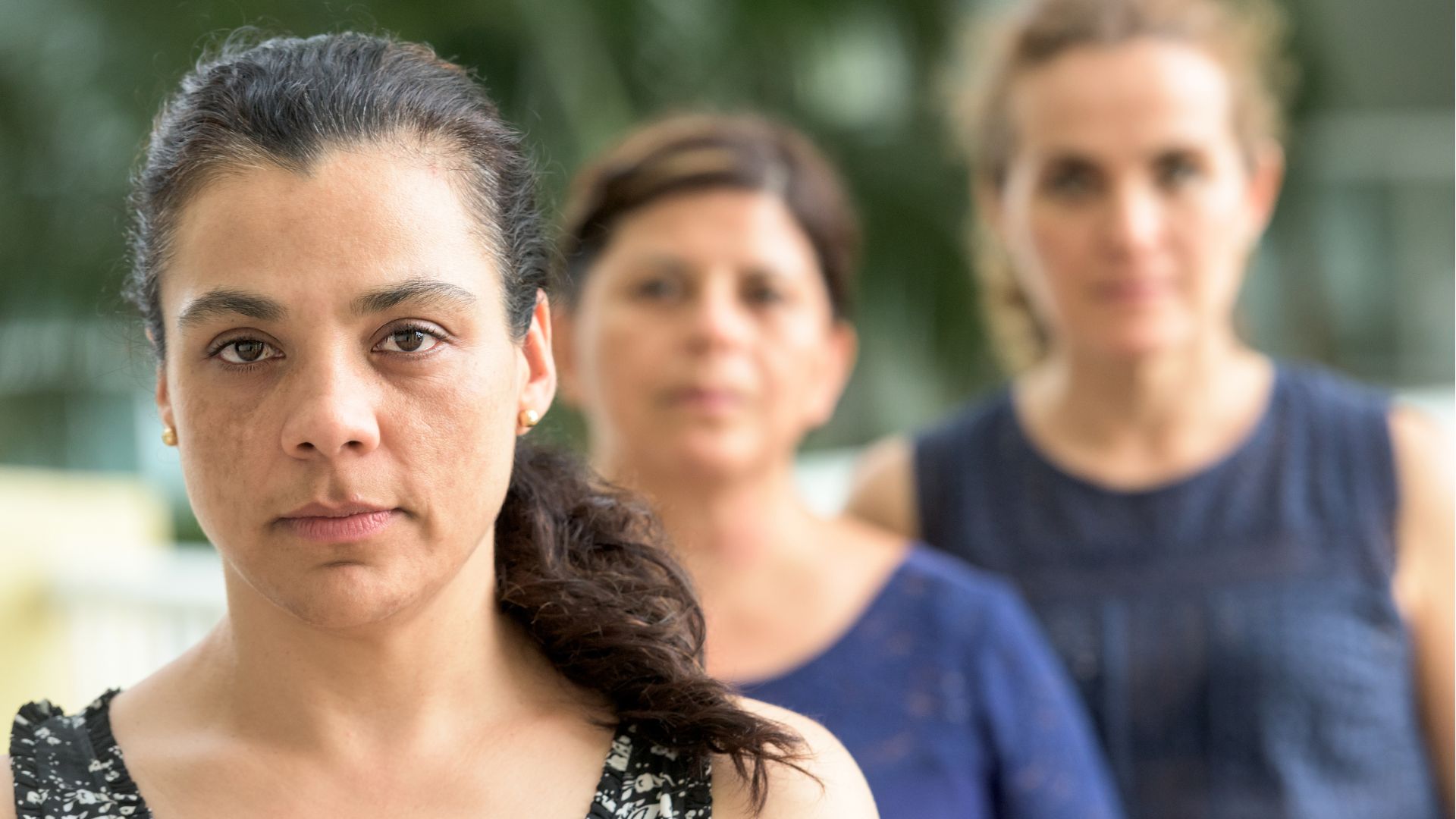 Tres mujeres mirando serias.